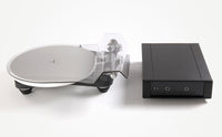 Turntable with a clear platter and black tonearm on a white background